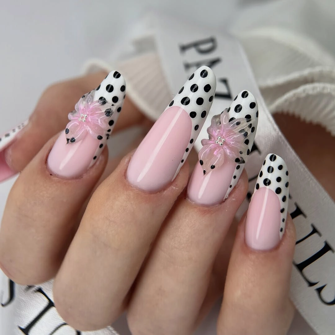 Pale pink nails with dotted French tips and pale floral accents