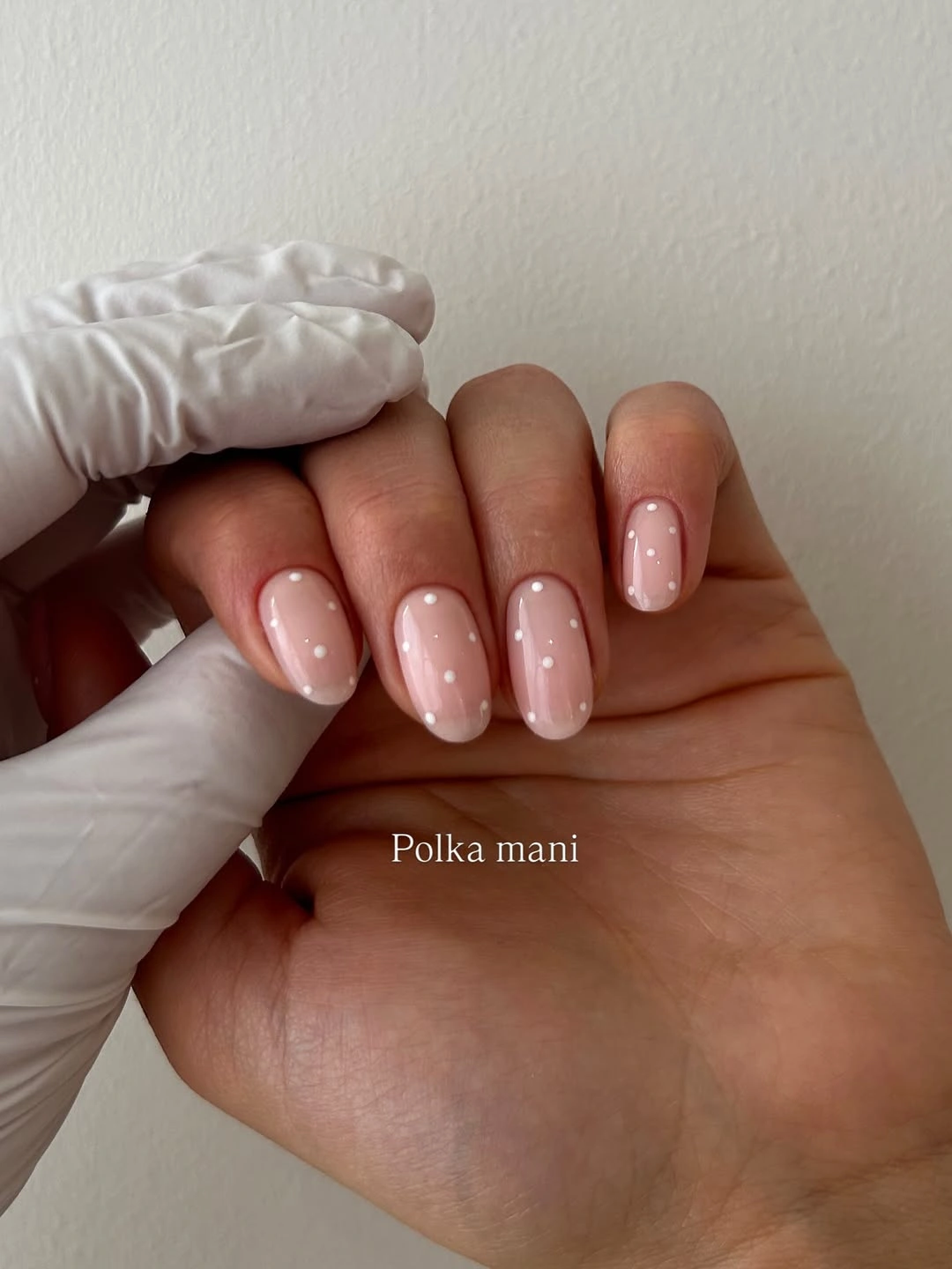 Short nude almond nails with tiny white and black tip dots