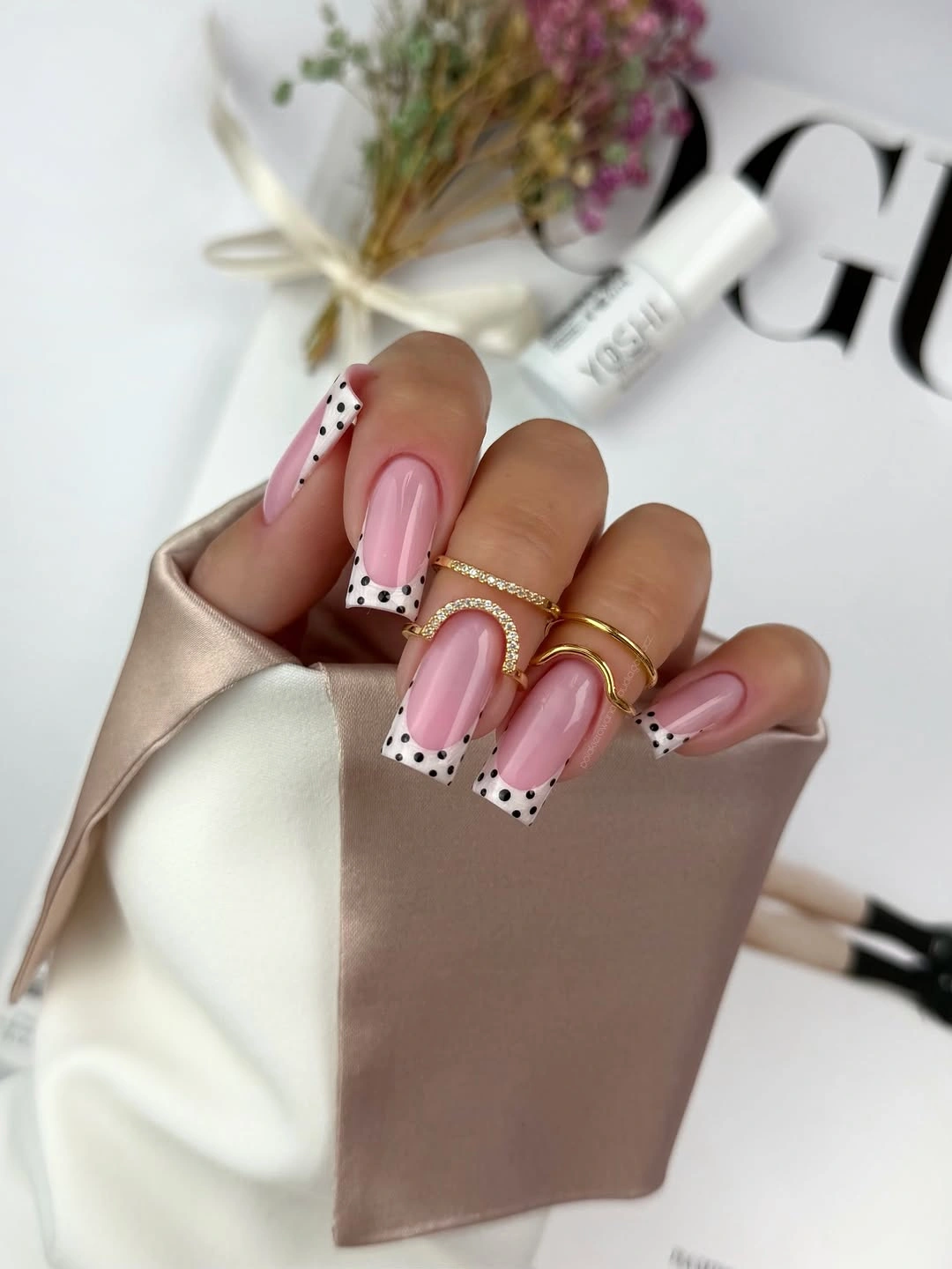 Long pink almond nails with black dotted white tips