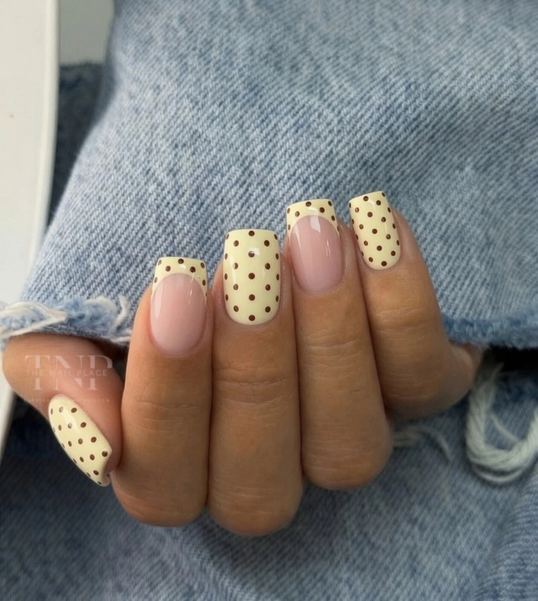 Medium square butter yellow nails with black dots and nude accents