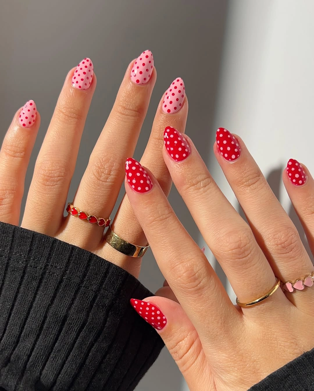 Red and pink almond nails with white dotted accents