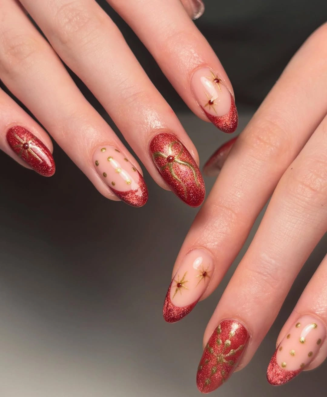 Pale pink and red glitter nails with gold starbursts