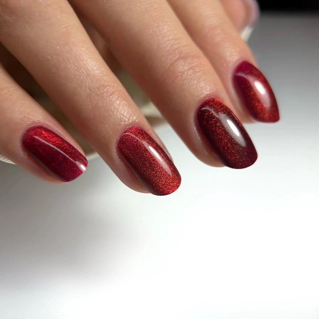 Medium almond nails in mostly uniform dark red shimmer