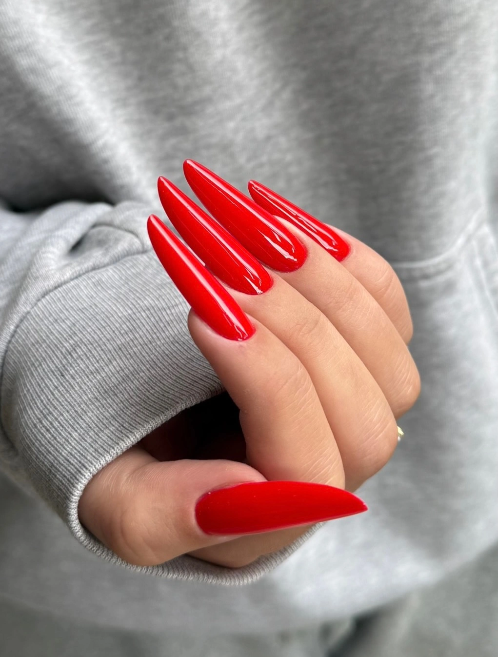 Very long bright red stiletto nails with glossy finish