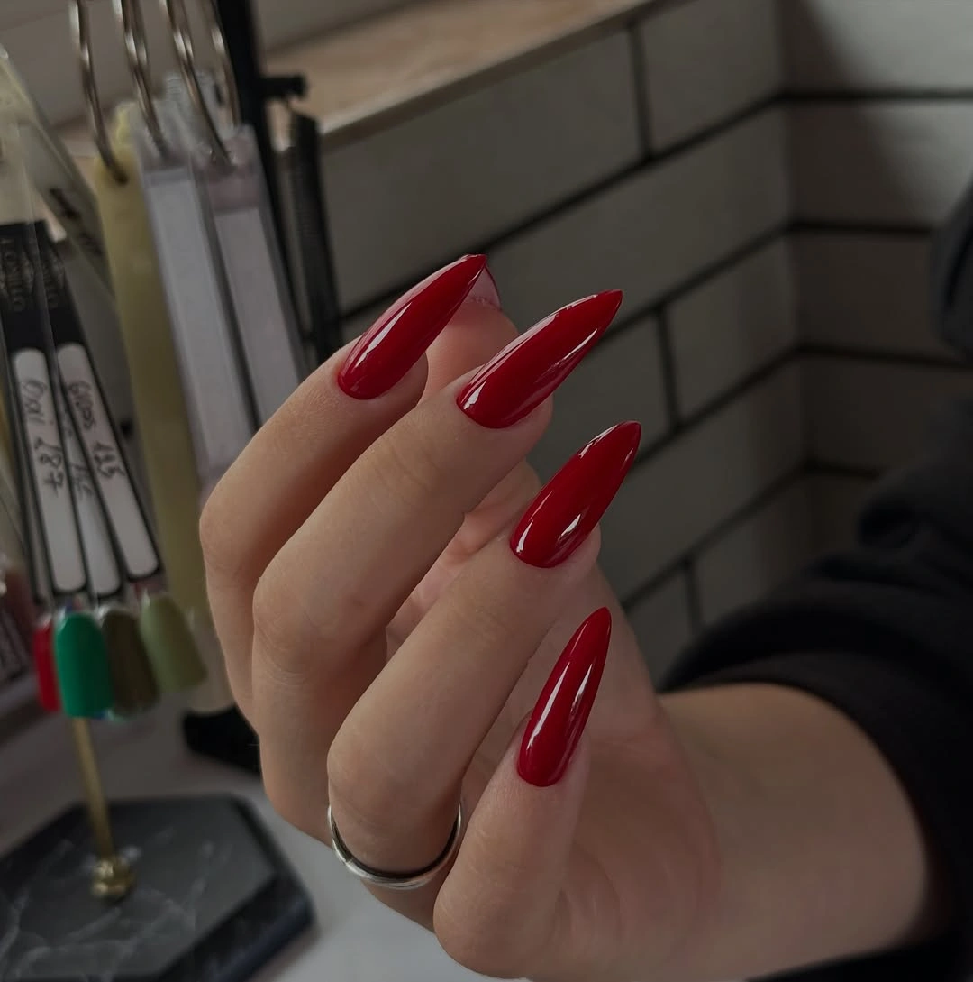 Long pointed burgundy red nails in solid glossy finish