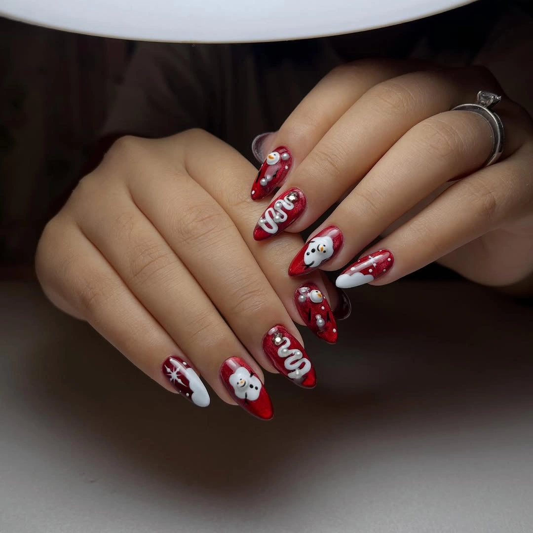 Dark red nails with white figures, bows, dots, and raised accents