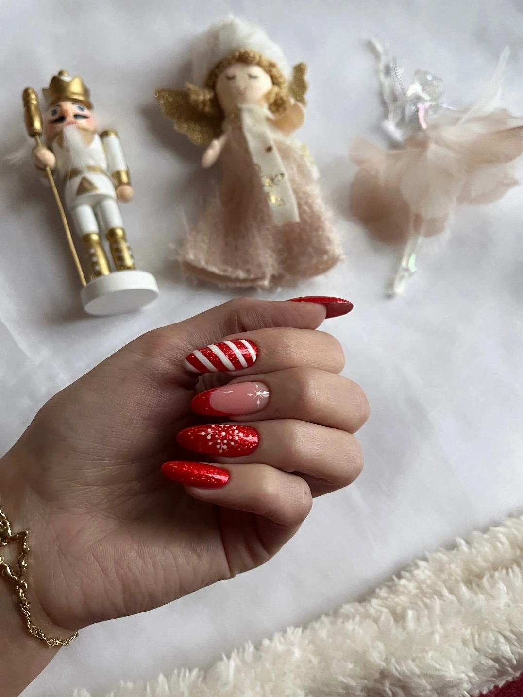 Red glitter nails with candy cane stripes and holiday figurines