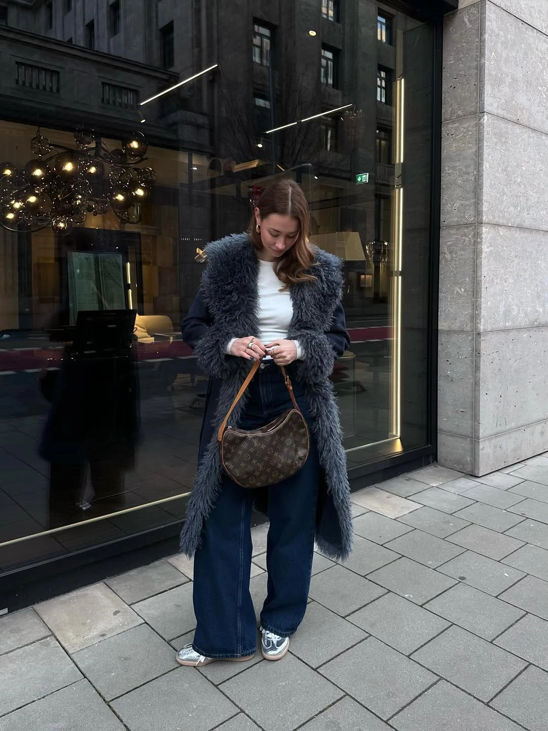 Blue gray fuzzy long coat with wide jeans and brown bag
