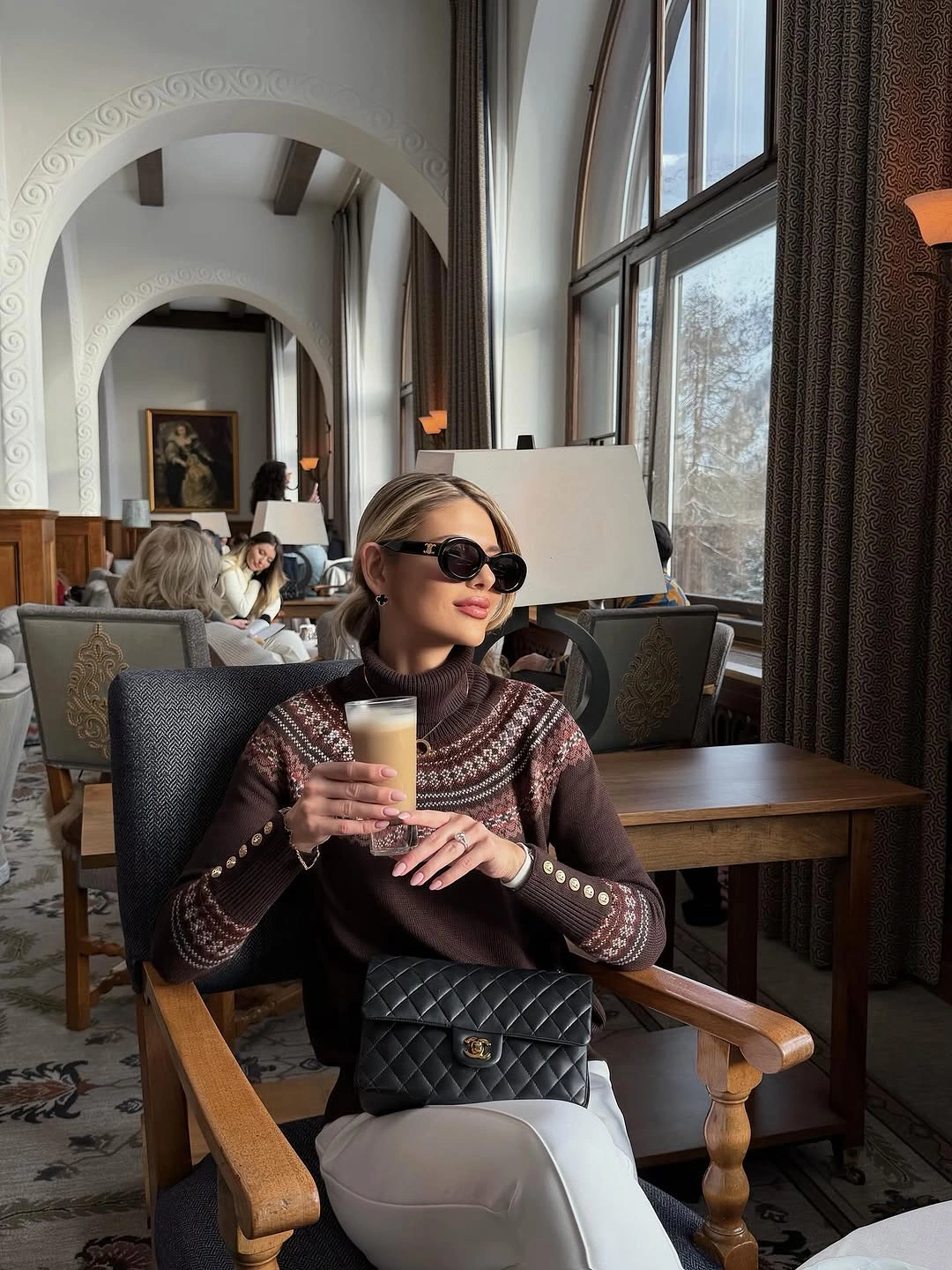 Dark striped sweater with gray trousers and quilted black bag