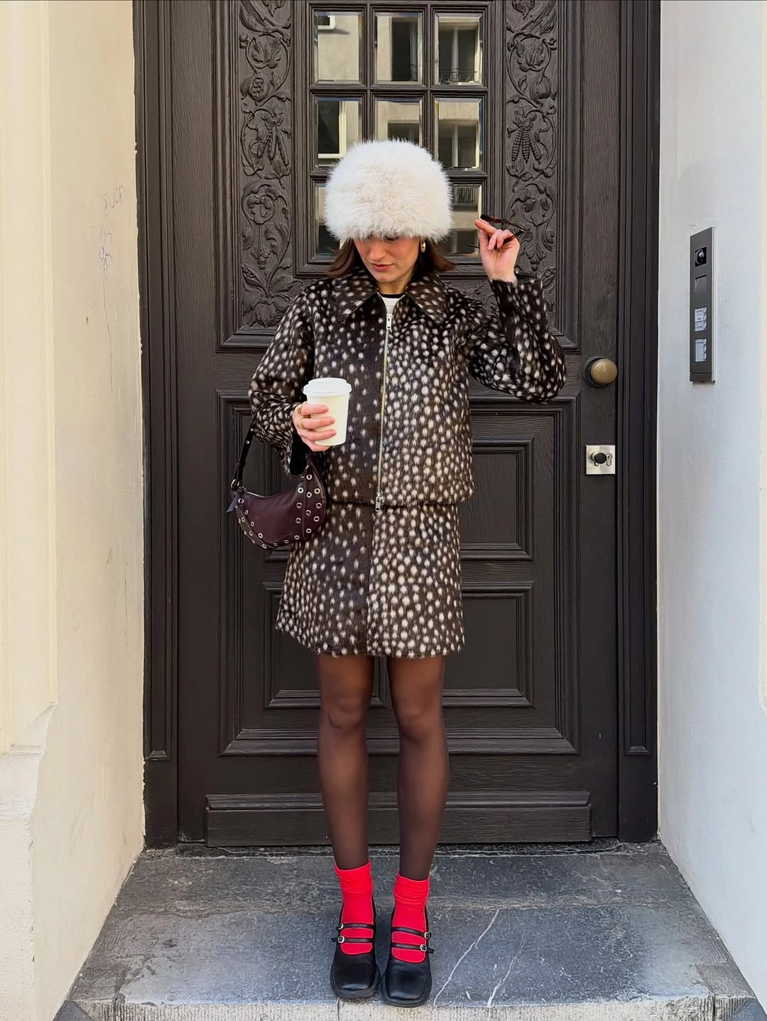 Spotted dark coat with white furry hat pink socks and black shoes