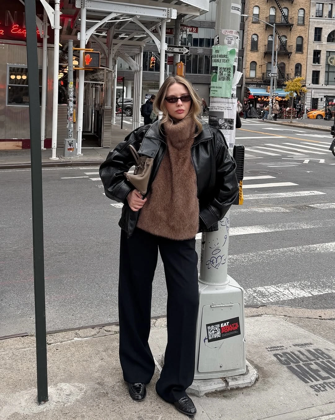 Black bomber jacket with taupe scarf wide trousers and loafers