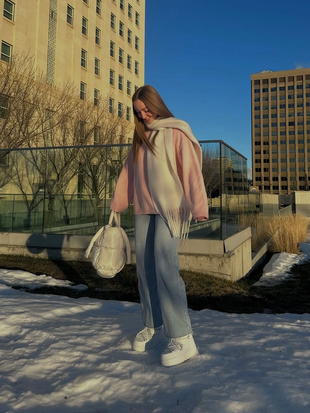 Camel draped poncho with loose gray trousers and light trainers
