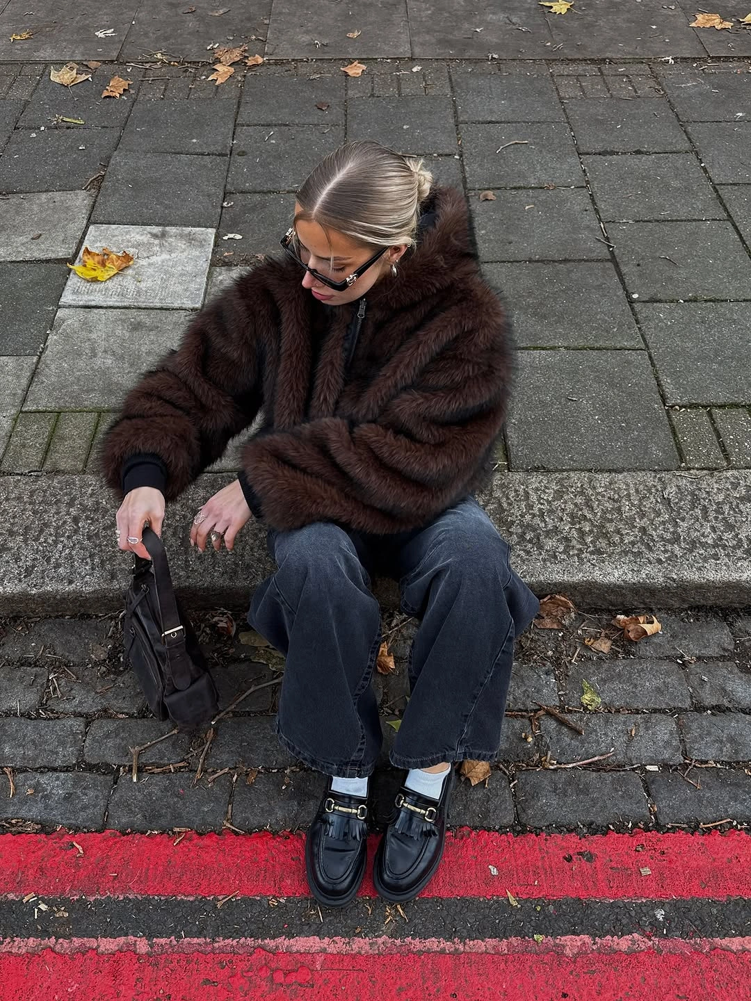 Dark fuzzy brown jacket with straight jeans black loafers and bag