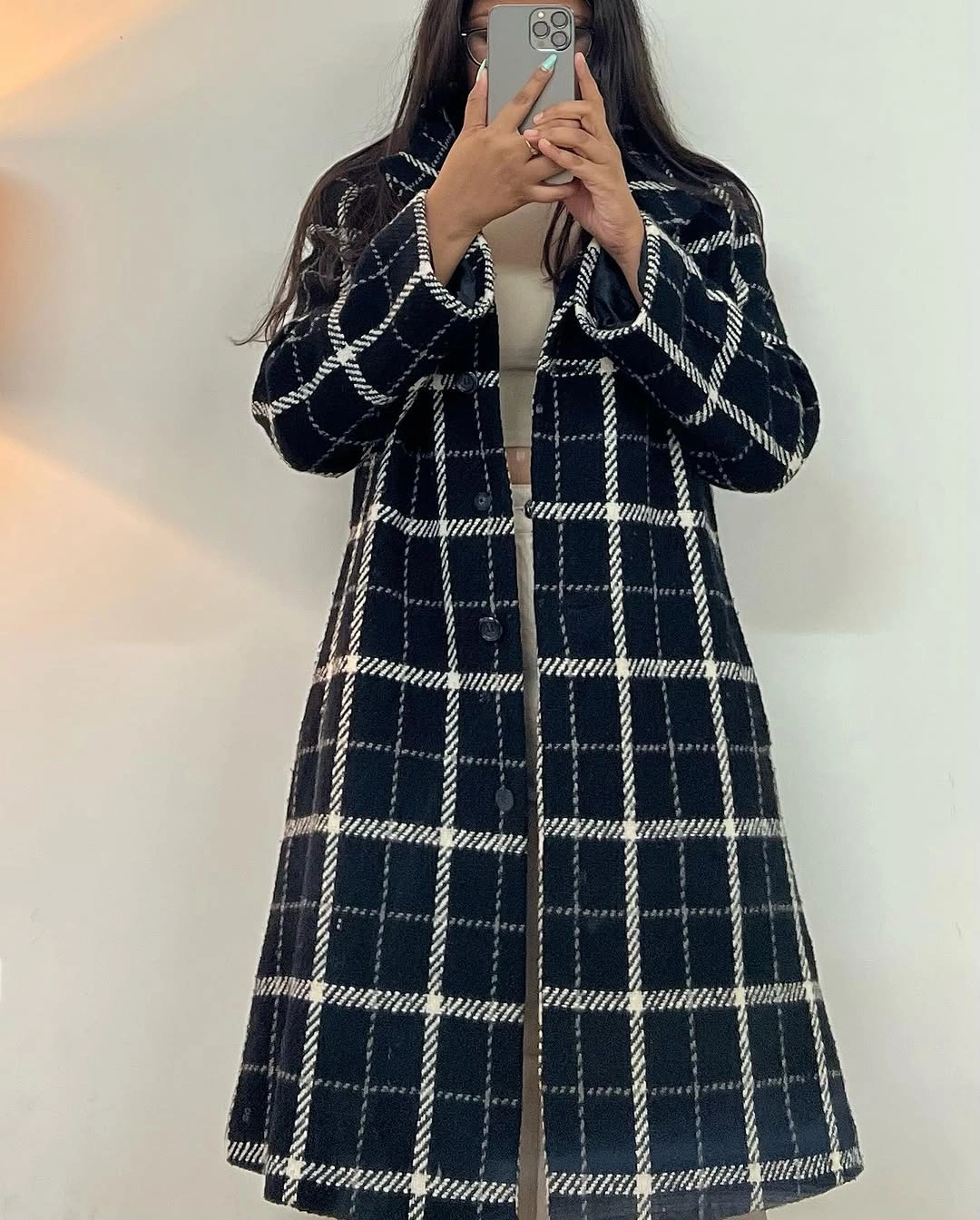 Black windowpane long coat over pale inner layer