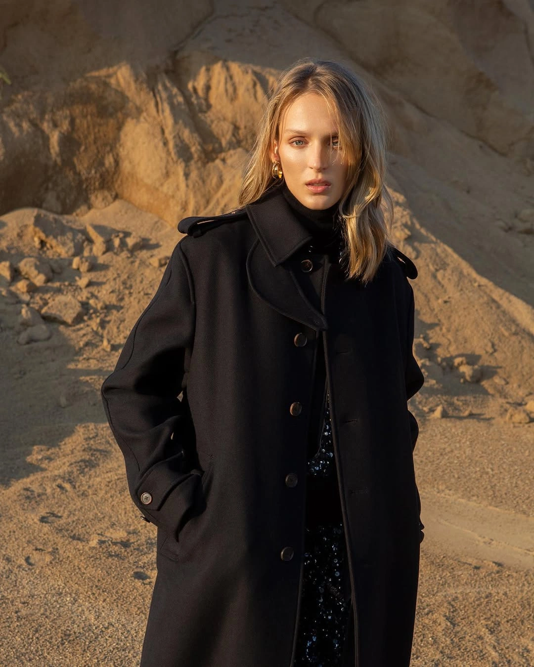 Black long double-breasted coat over black high-neck layer