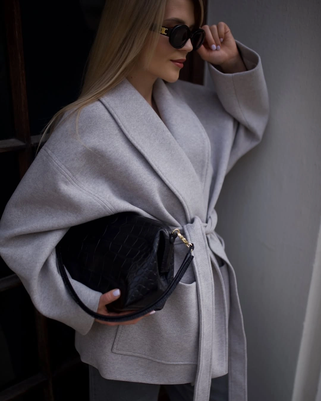 Pale gray short belted wrap coat with black quilted bag