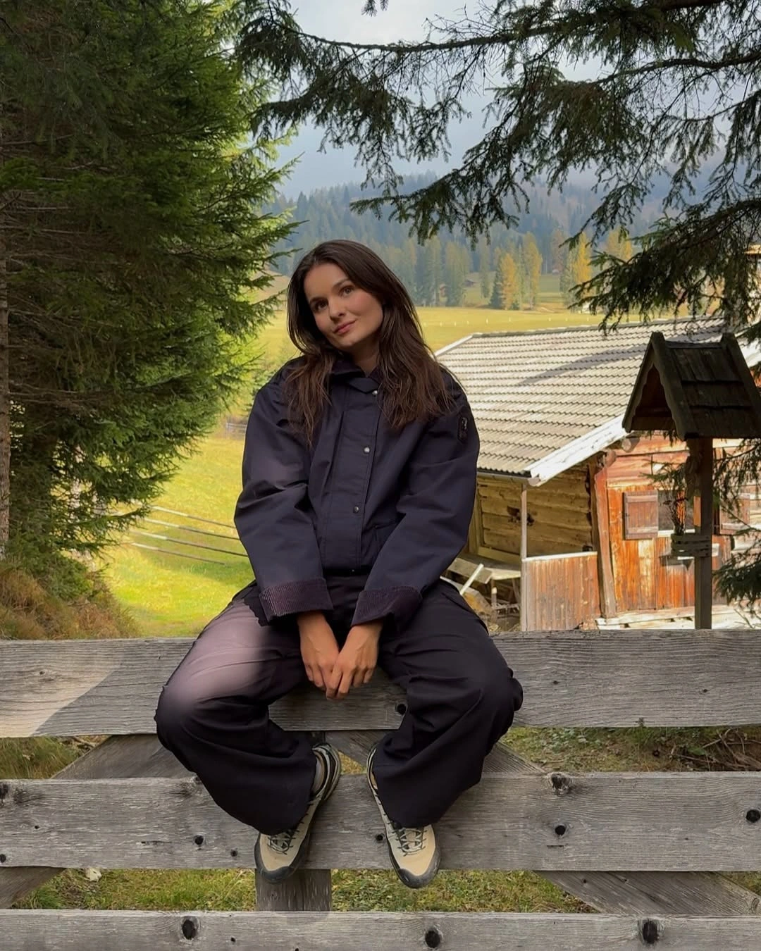 Dark oversized padded jacket with wide pants and light-soled sneakers