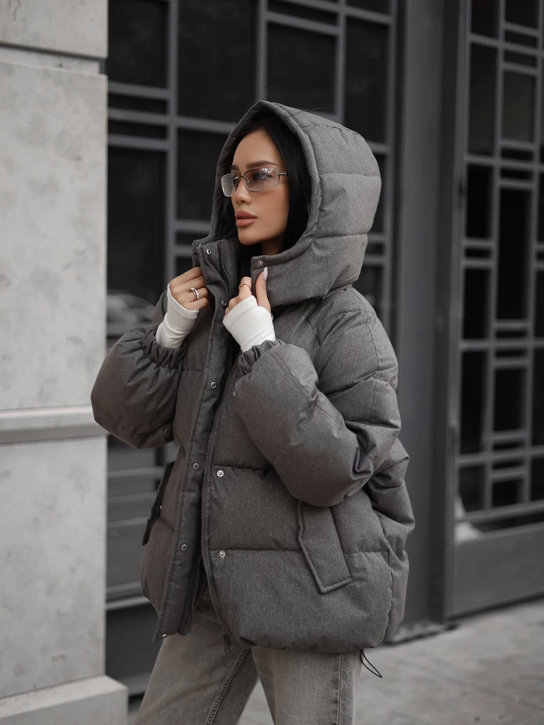 Gray hooded padded jacket with gray lower half and sunglasses