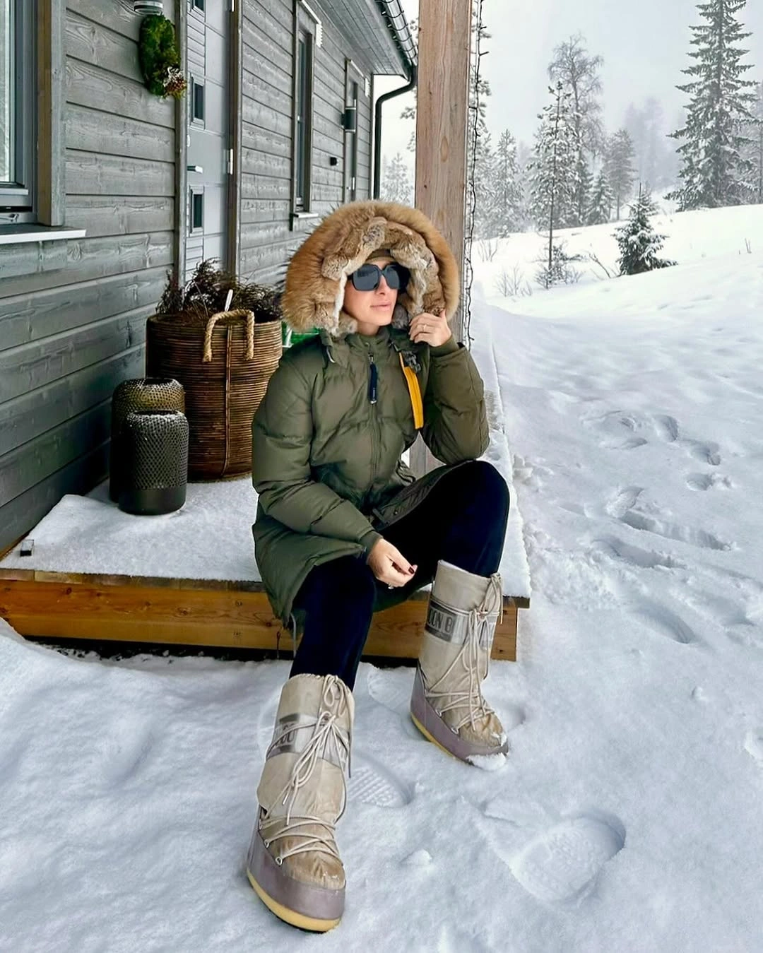 Green padded coat with fur-looking trim and beige tall boots