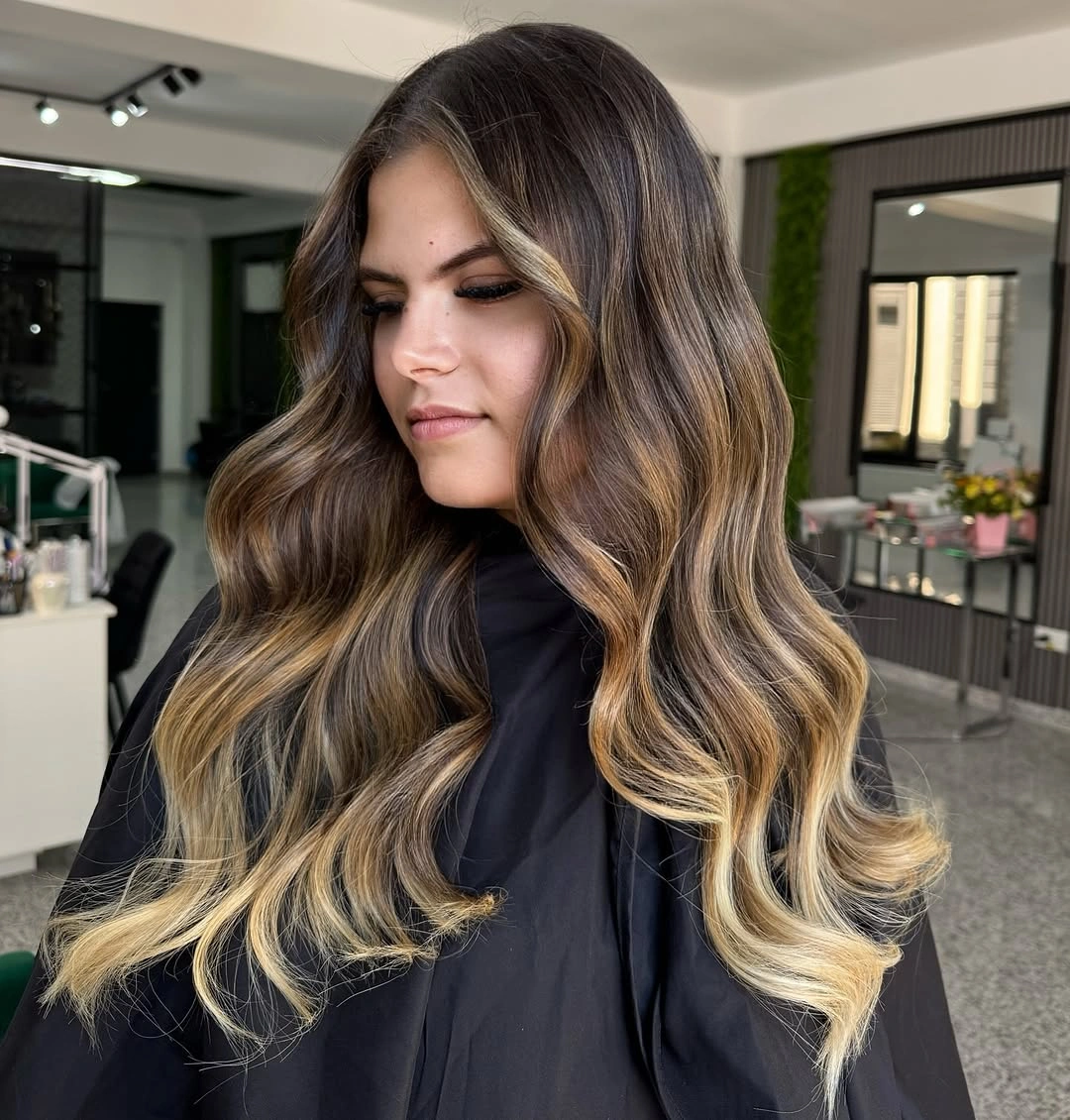 Long wavy hair with dark roots and golden blonde ends