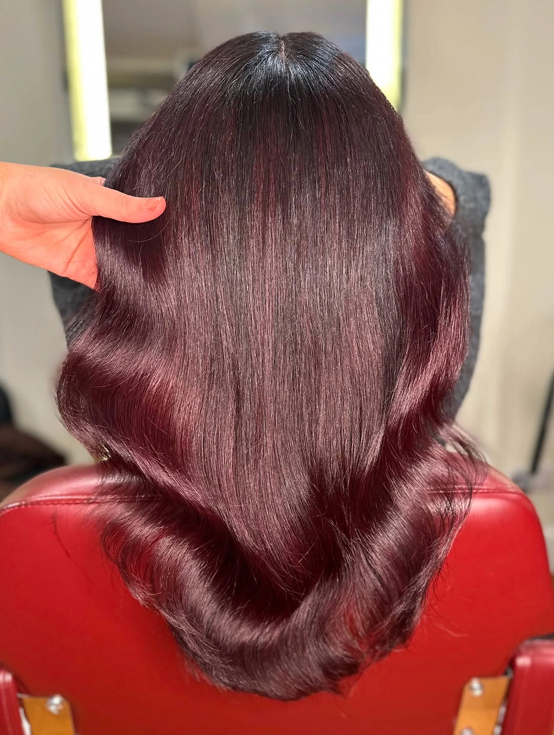 Burgundy red wavy layered hair from back view