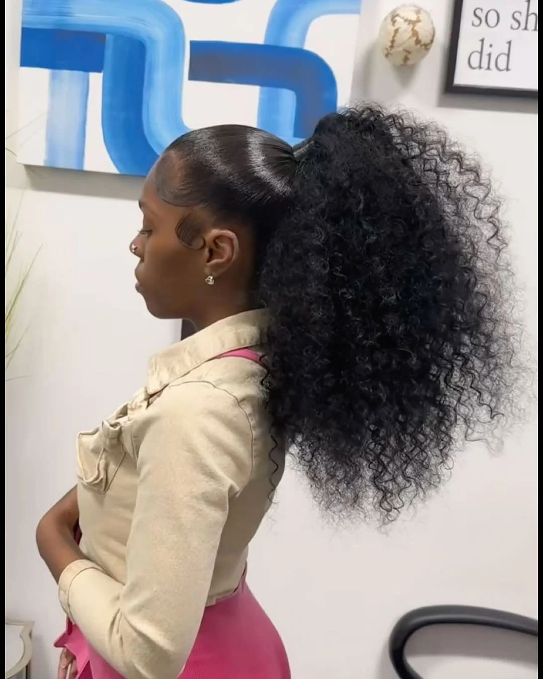 Sleek high ponytail base with large black curly volume