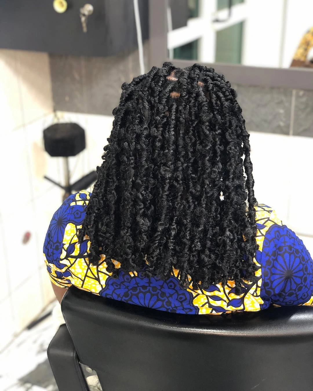 Short black curled twisted sections with rounded shoulder shape
