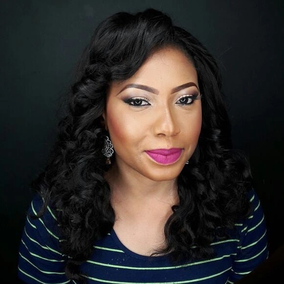Shoulder-length black curls with polished side-parted shape