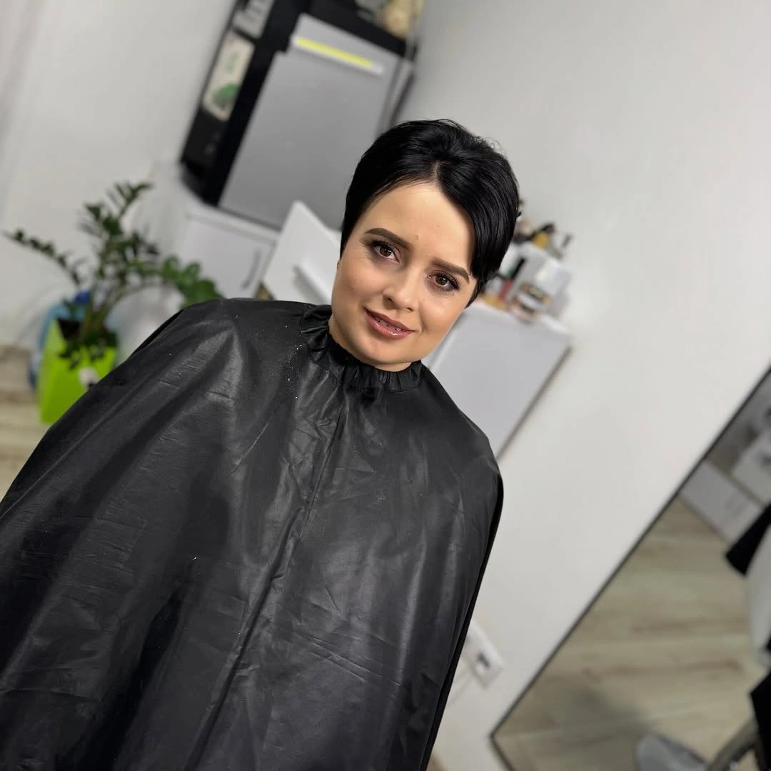 Short dark textured pixie-bob with salon cape