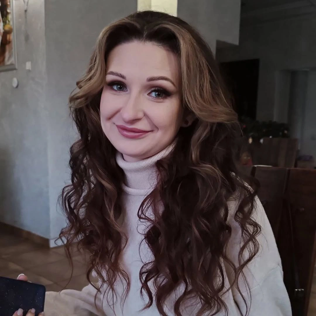 Long dark-brown curly hair with defined face-framing curls