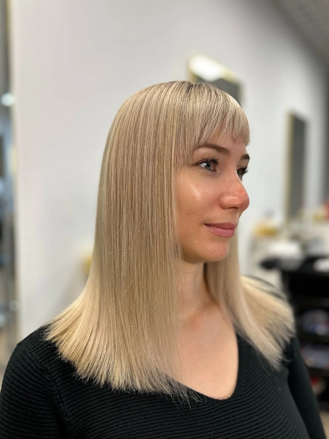 Straight blonde long bob with short fringe and shoulder-level ends