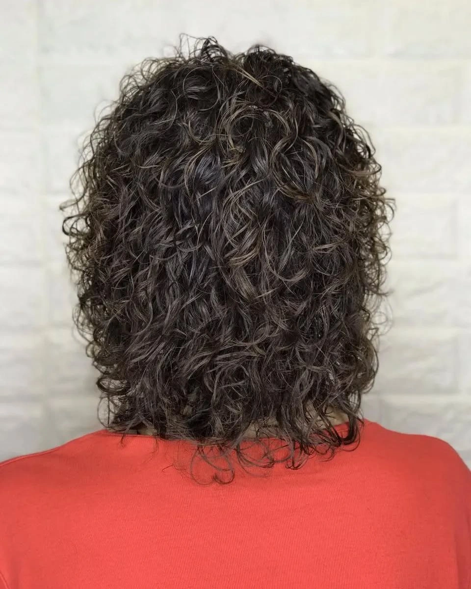 Short dark curly haircut viewed from behind