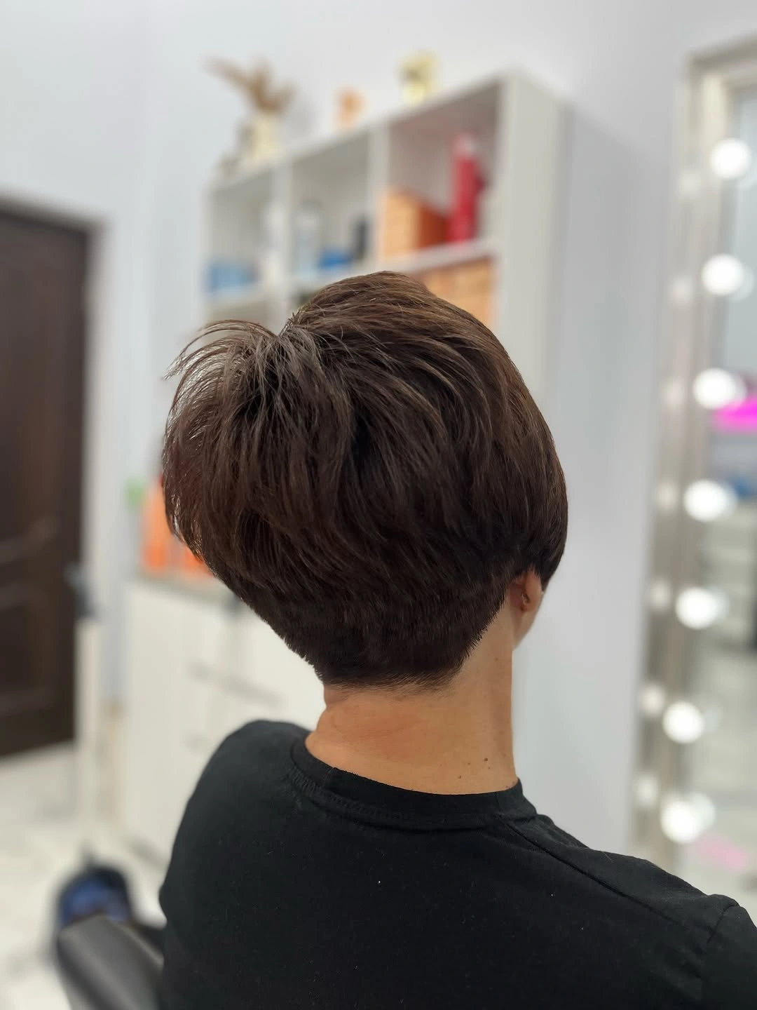 Short dark pixie haircut viewed from behind