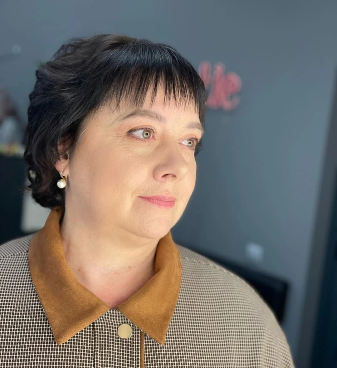 Short dark pixie haircut with straight bangs
