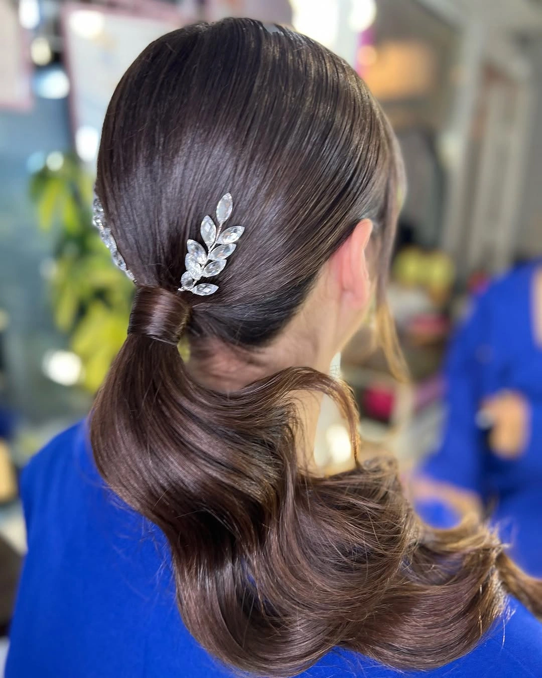 Dark low ponytail with decorative clip at back