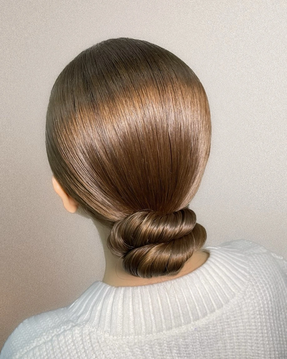 Sleek brown low bun with rounded rolled shape