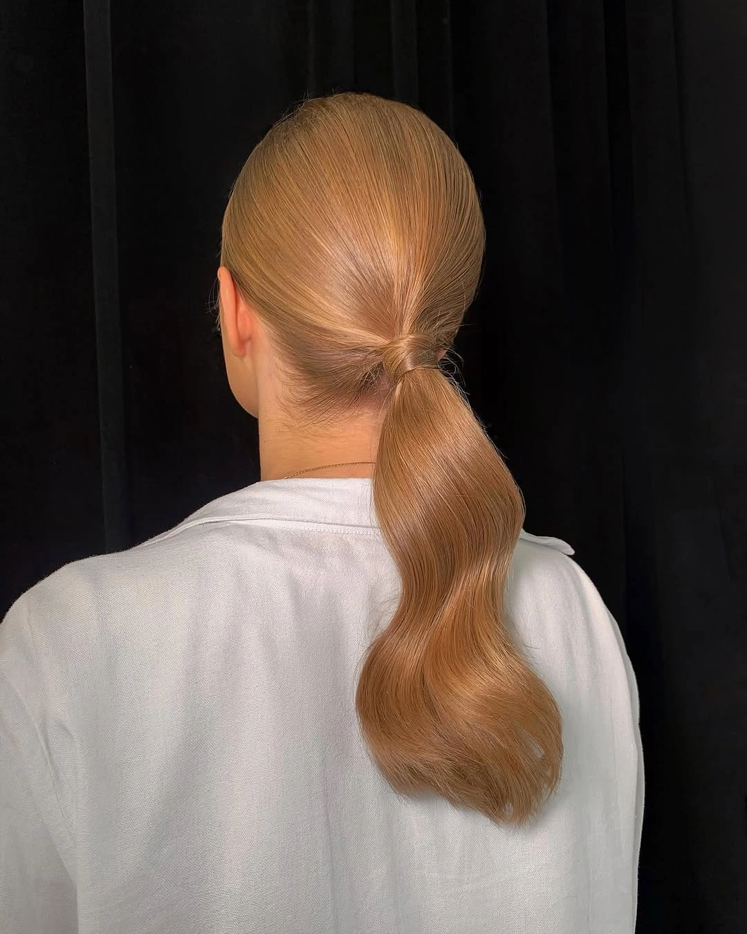 Sleek blonde ponytail with smooth back and wavy tail