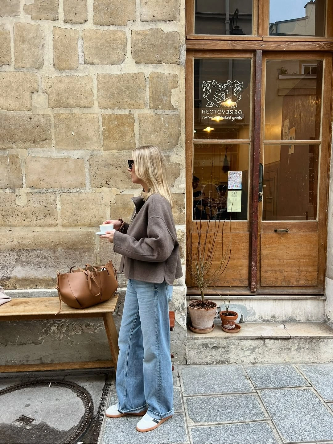 Taupe gray sweater with wide jeans and tan bag