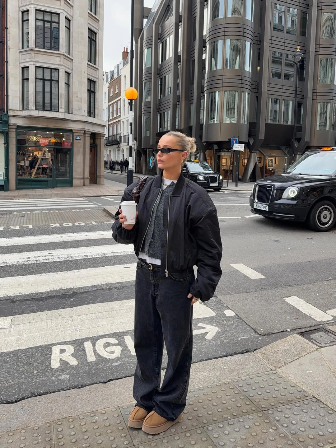 Black jacket with dark wide denim and tan shoes