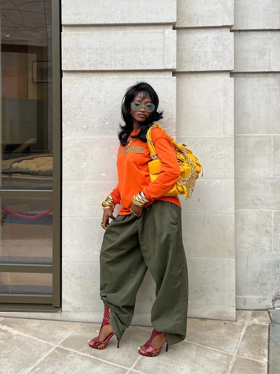 Orange sweatshirt with olive pants and red patterned heels