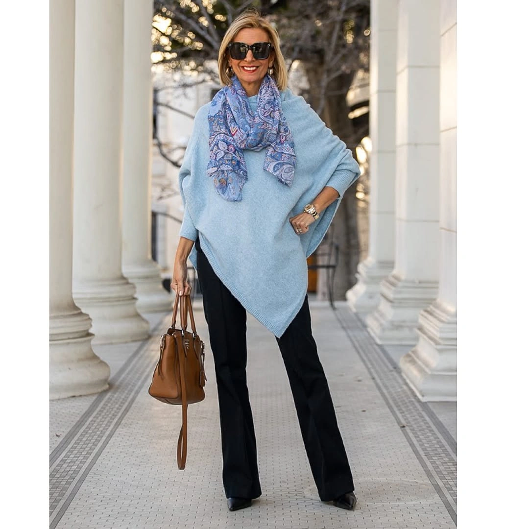 Light blue poncho-style top with scarf and black trousers