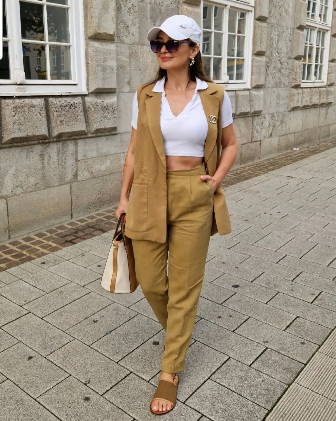 Tan sleeveless vest and trousers with white cap
