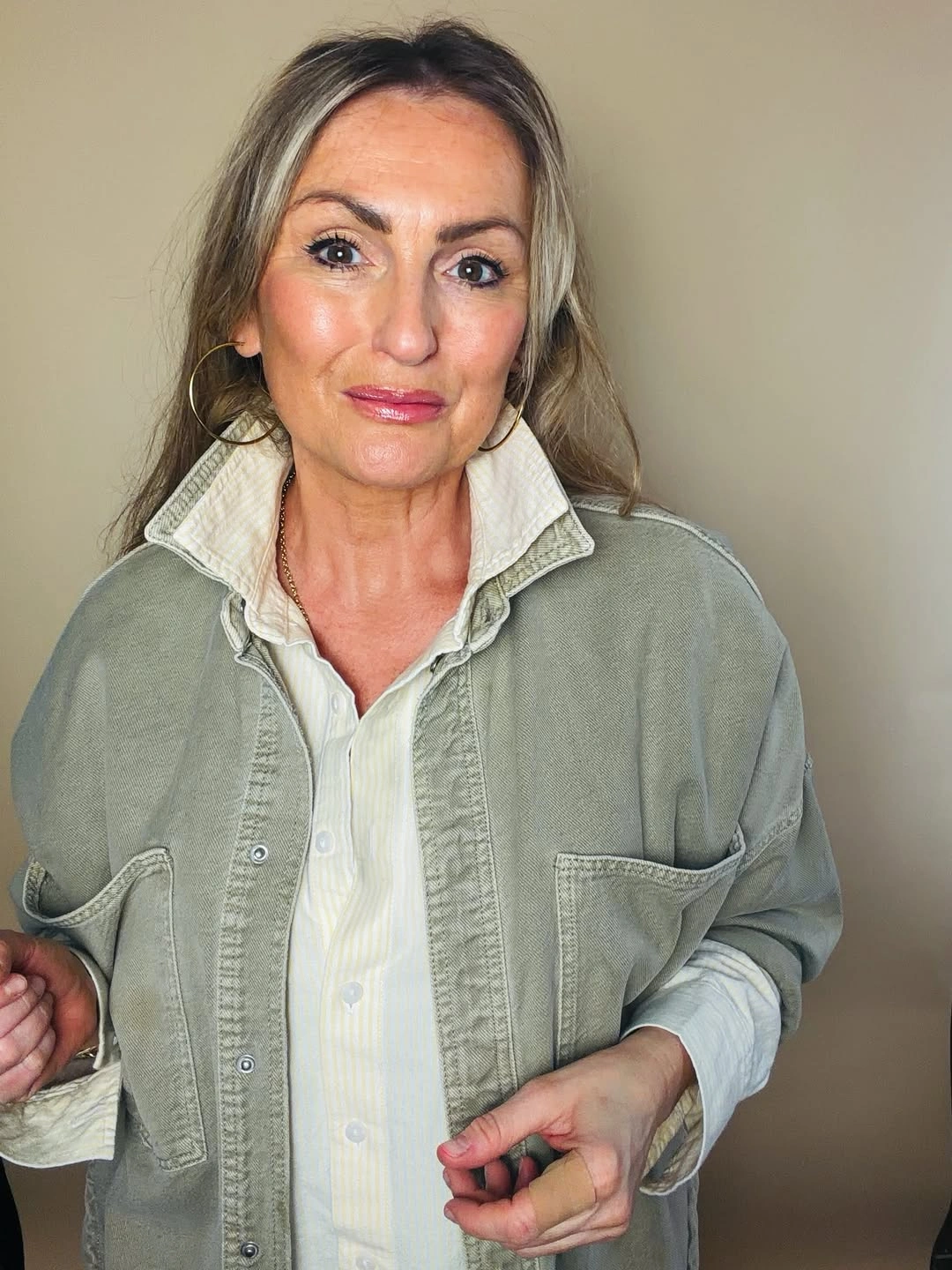 Sage green overshirt layered over cream button-down shirt