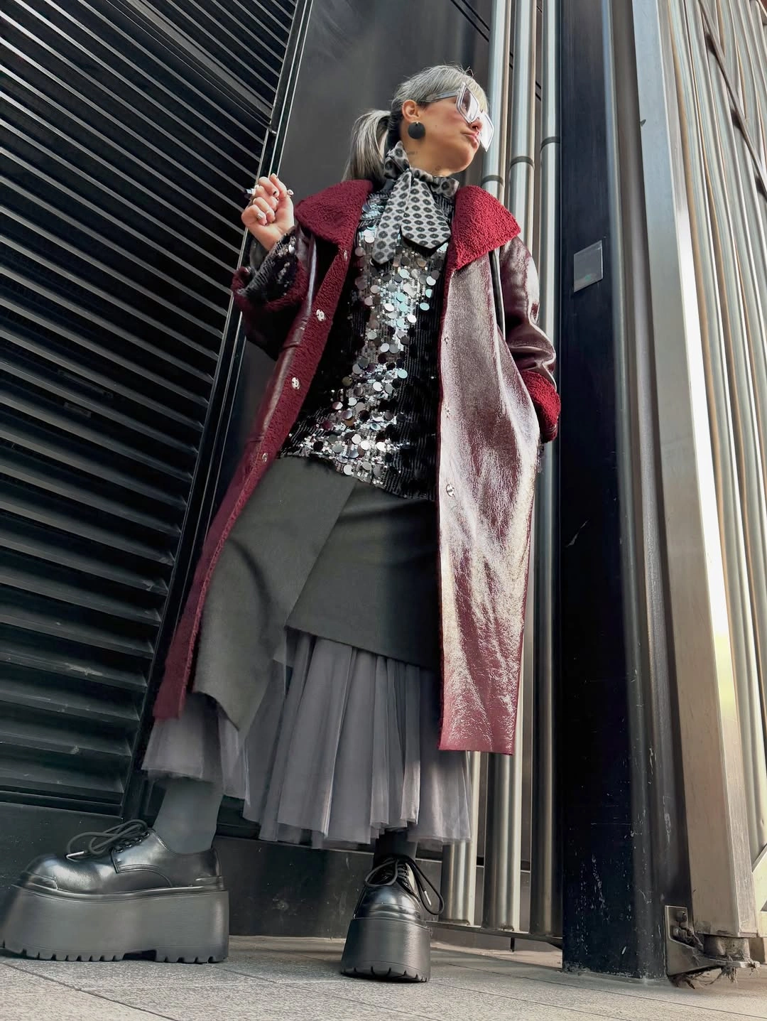 Shiny burgundy coat with reflective top and layered gray skirt