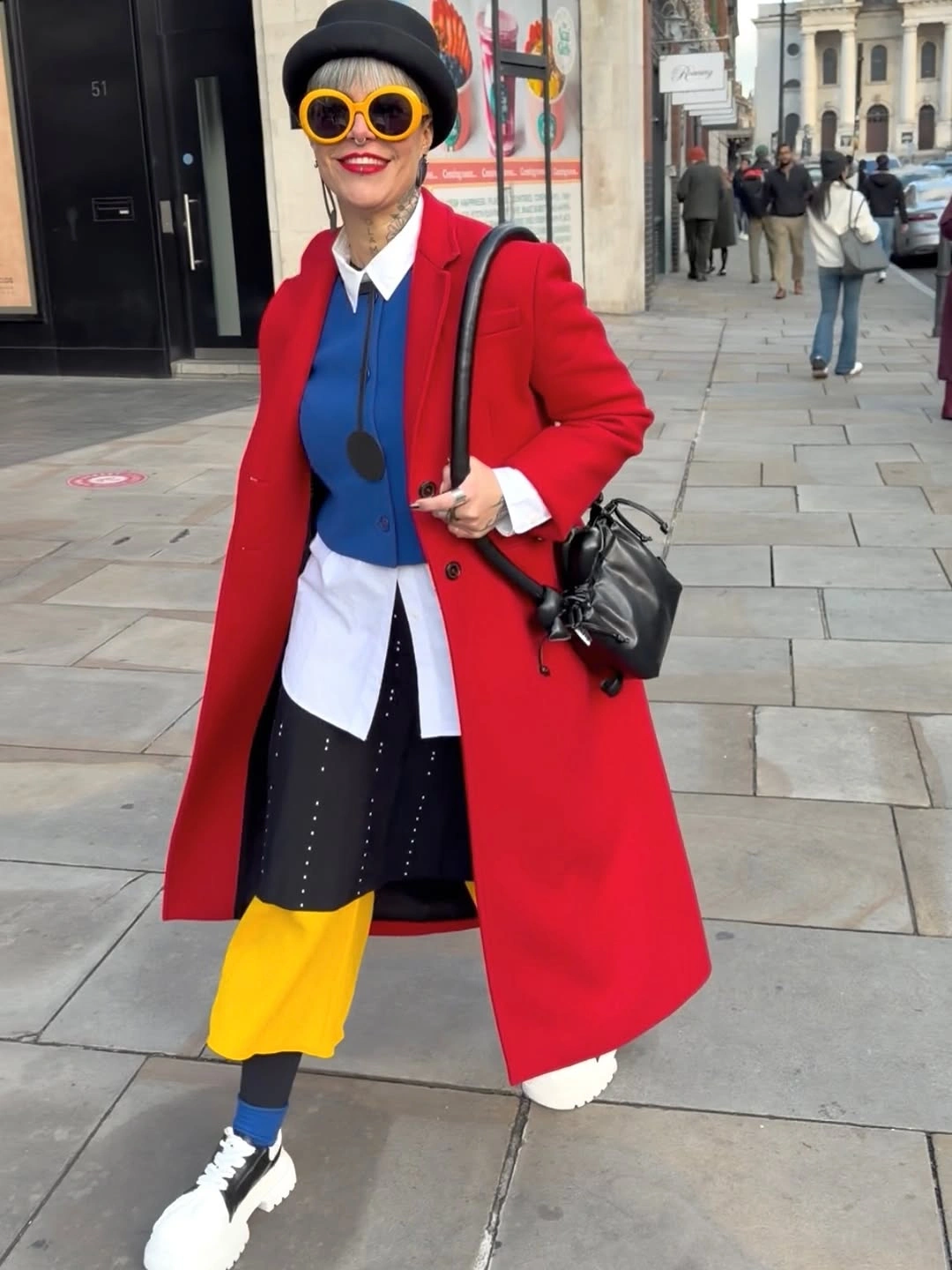 Red coat with blue vest, yellow lower layer and sneakers