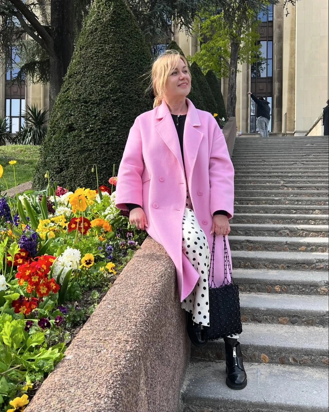 Pink coat with polka-dot lower layer and black boots