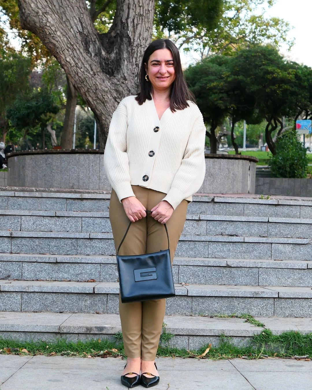 Ivory cardigan with tan pants and black pointed flats