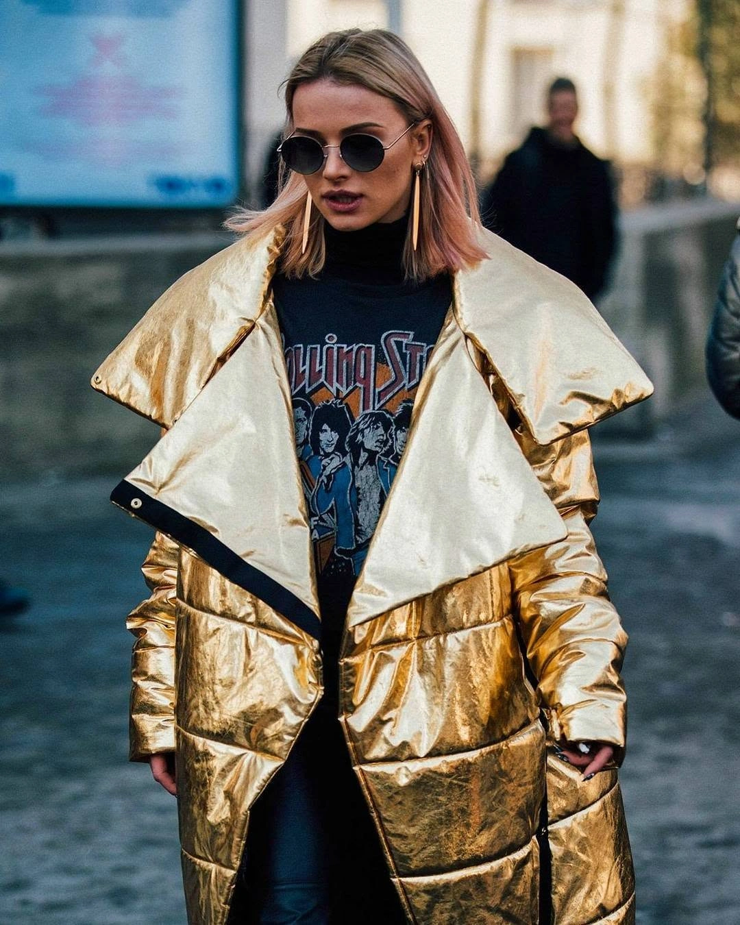 Metallic-looking gold puffer with wide collar and dark graphic top
