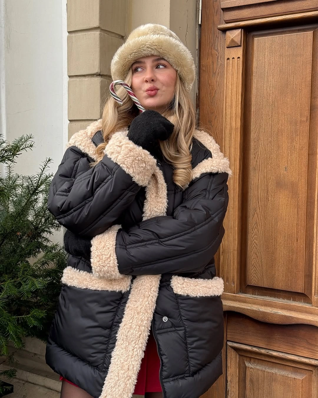 Black quilted puffer with cream fuzzy-looking trim, hat, and gloves