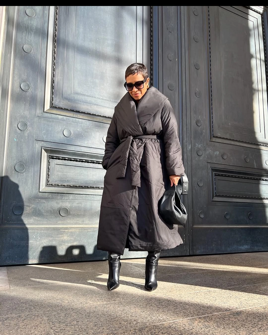 Long dark belted puffer coat with pointed black boots